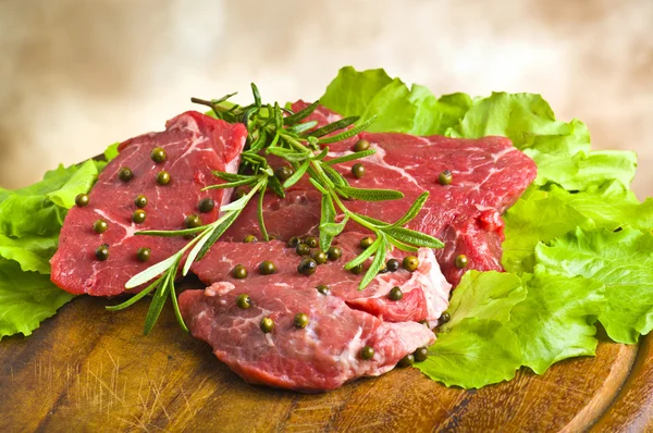 Rij biefstuk whit groene peper en rozemarijn op plaat van hout — Stockfoto