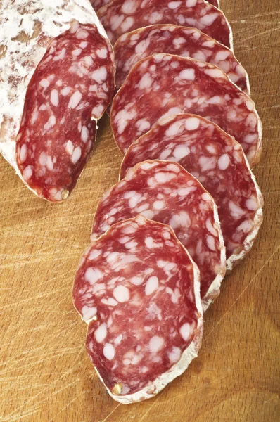 Salami with slices on wood — Stock Photo, Image