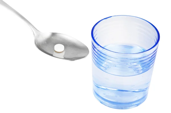 Pil on the spoon and glass of water — Stock Photo, Image