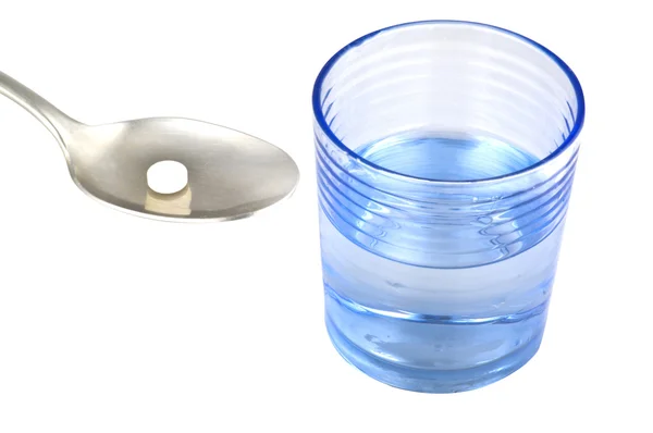 Medicina en una cuchara y un vaso de agua — Foto de Stock