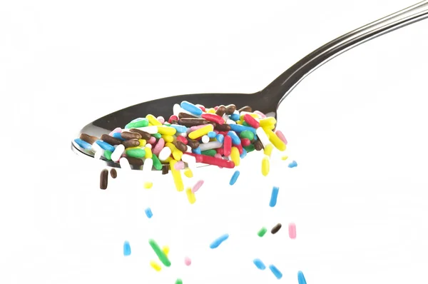 Gekleurde snoepjes op een lepel — Stockfoto