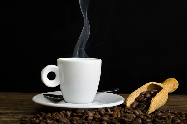 Steaming coffee and coffee beans — Stock Photo, Image