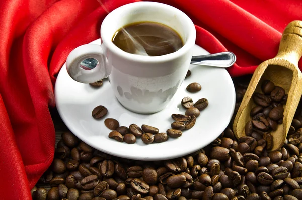 Dampfender Kaffee und Kaffeebohnen — Stockfoto