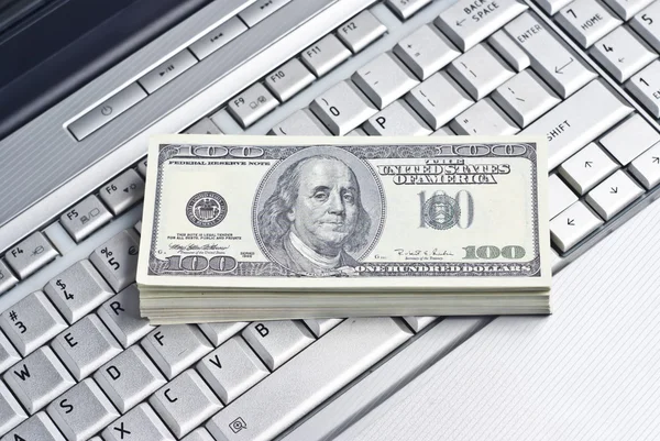 Dinheiro deitado em um laptop — Fotografia de Stock