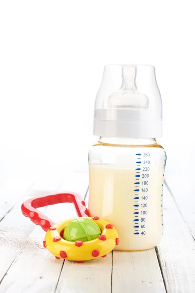 Baby bottle with toy — Stock Photo, Image