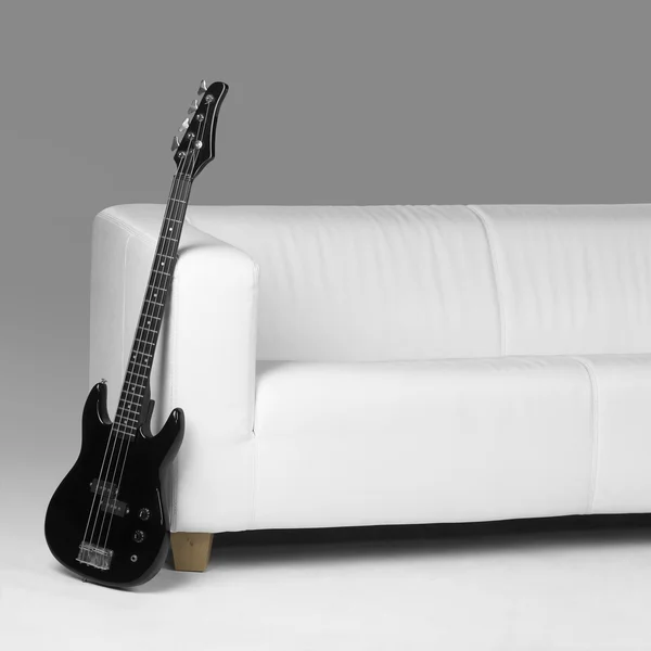 Μαύρο μπάσο κιθάρα και λευκό καναπέ — Φωτογραφία Αρχείου
