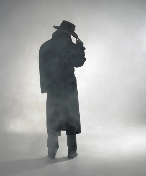 stock image Woman wearing trench coat and standing in fog