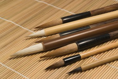 Chinese brushes on wooden mat detail clipart