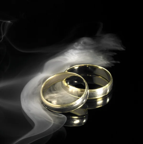 Golden wedding rings and smoke — Stock Photo, Image