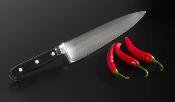 Küchenmesser und Chilischoten — Stockfoto