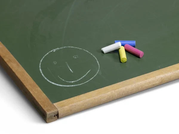 Blackboard with smiley and crayons — Stock Photo, Image