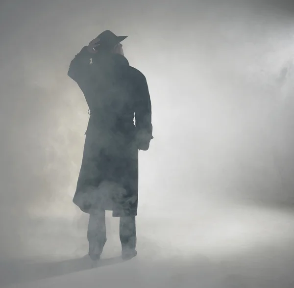 Frau trägt Trenchcoat und steht im Nebel — Stockfoto