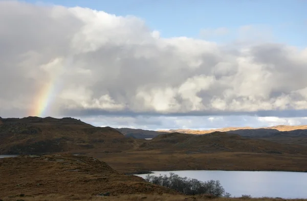 Шотландский пейзаж с радугой и драматическим небом — стоковое фото