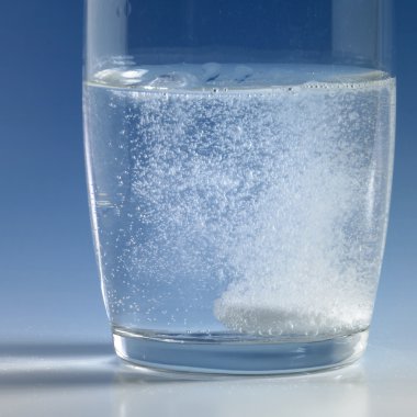 Fizzy tablet in a glass of water clipart