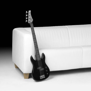 Black bass guitar and white couch clipart