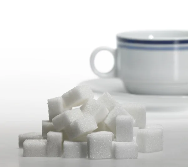 Kusový cukr a porcelánový kávový šálek — Stock fotografie