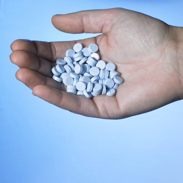 Ręka trzyma niebieskich tabletek — Zdjęcie stockowe