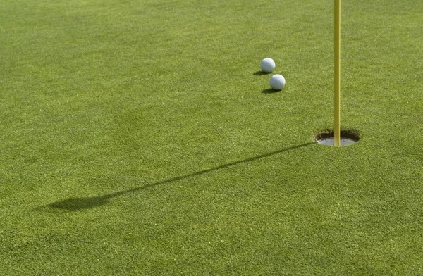 Hole a golfové míčky v zelené zpět — Stock fotografie