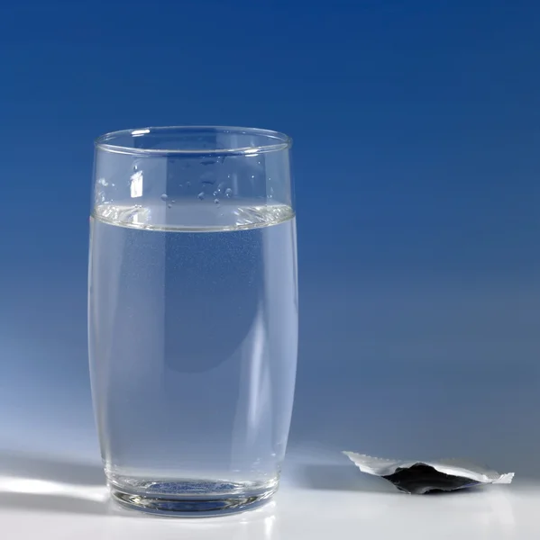 Szklanką wody w tył niebieski — Zdjęcie stockowe