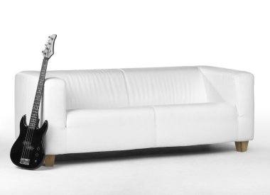 Black bass guitar and white couch clipart