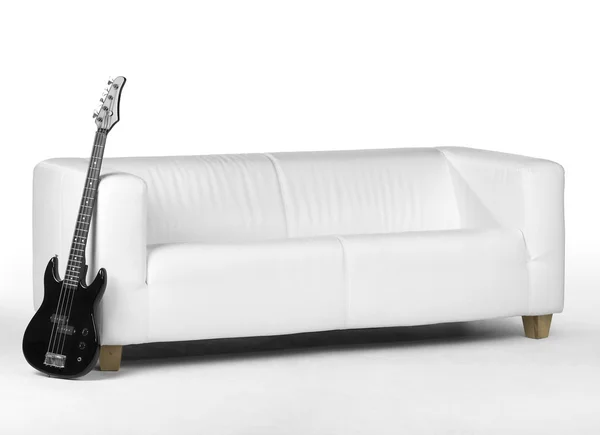 Guitare basse noire et canapé blanc — Photo
