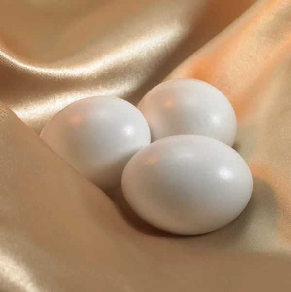 Eggs on satin — Stock Photo, Image