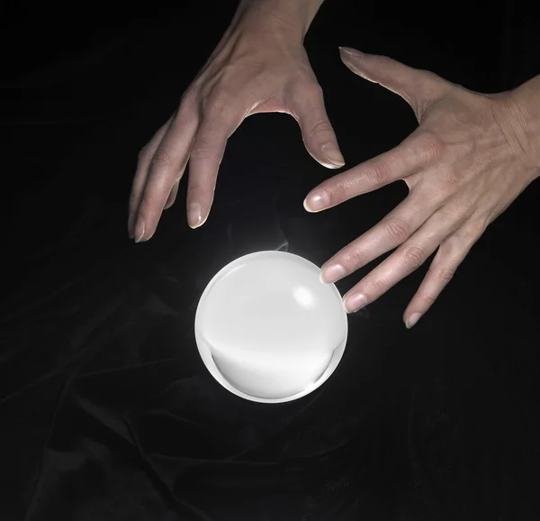 Bola de cristal e mãos ao redor — Fotografia de Stock