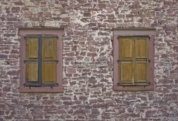 Stone wall with old windows — Stock Photo, Image