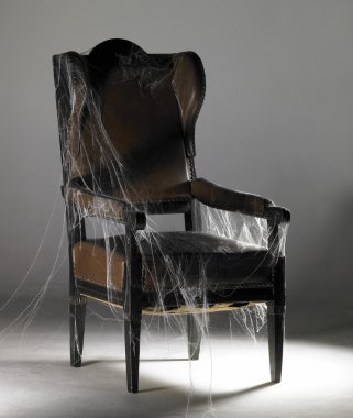 Brown wing chair and cobwebs clipart
