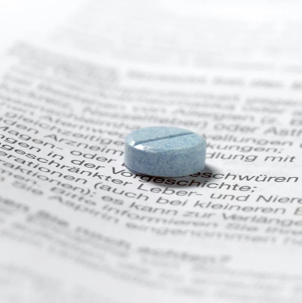Blue pills on package insert — Stock Photo, Image