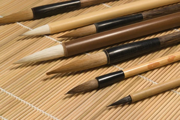 Chinese brushes on wooden mat detail — Stock Photo, Image