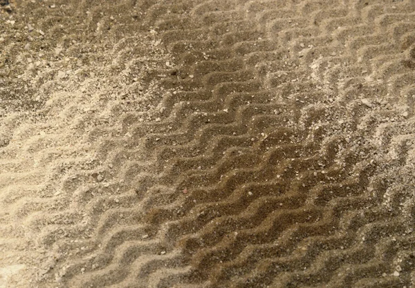 Vågiga linjer på brun sand yta — Stockfoto