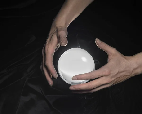 Bola de cristal e mãos ao redor — Fotografia de Stock