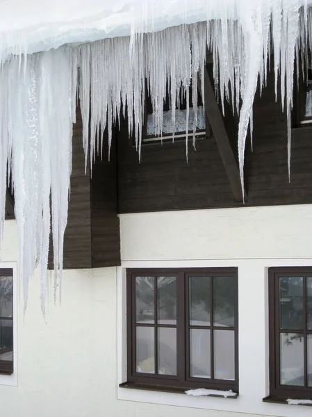 Eiszapfen vor einer Hausfassade — Stockfoto