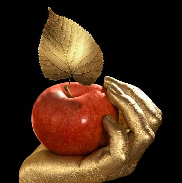 Золотая рука и яблоко — стоковое фото