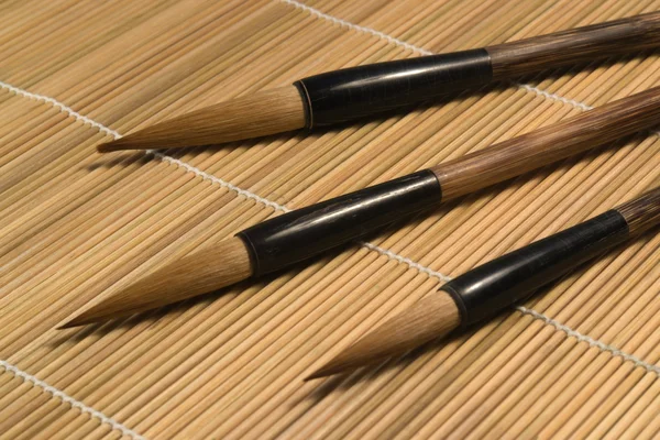 Chinese brushes on wooden mat detail — Stock Photo, Image