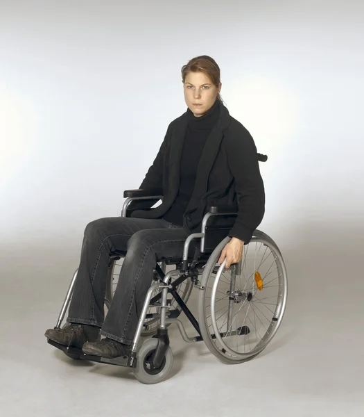 Donna seduta su una sedia a rotelle — Foto Stock