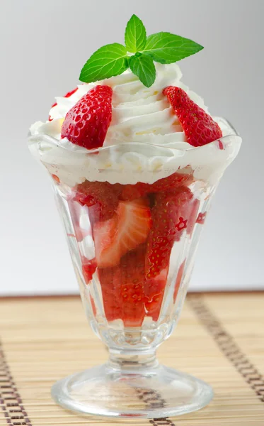 stock image Fresh chopped strawberries with whipped cream and mint in glasswares