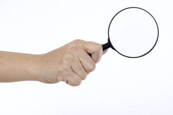 Woman's hand picking up a magnifying glass on a white background