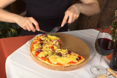 Woman Eating Vegetarian Pizza in a Restaurant clipart