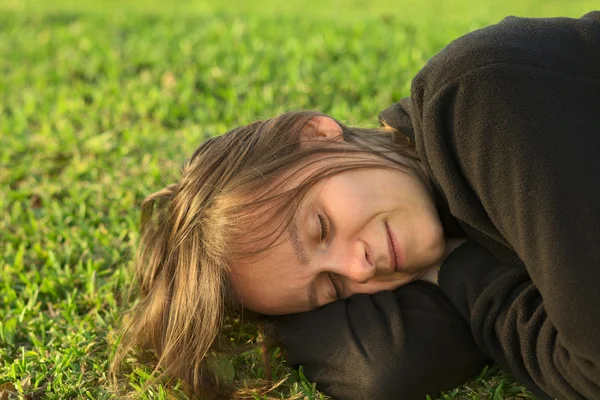 Jonge vrouw slapen op gras — Stockfoto