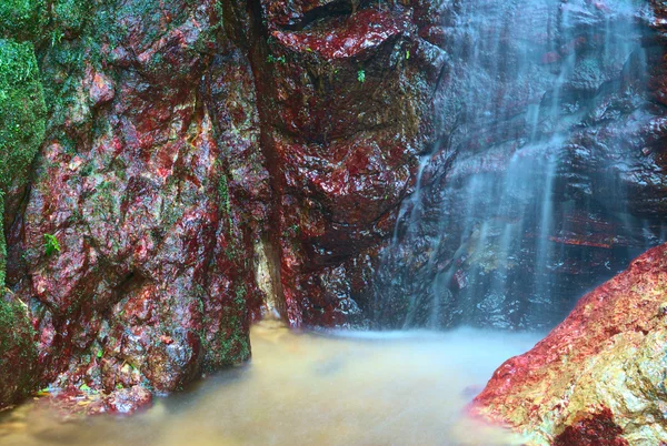 Malý vodopád, obklopený barevnými kameny — Stock fotografie
