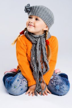 Little fashionable girl in warm clothes clipart