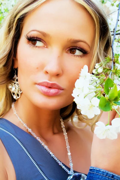 Mooie vrouw met een kersenboom bloemen — Stockfoto