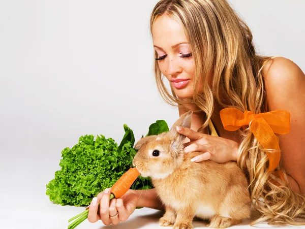 Веселая девушка кормит кролика. — стоковое фото