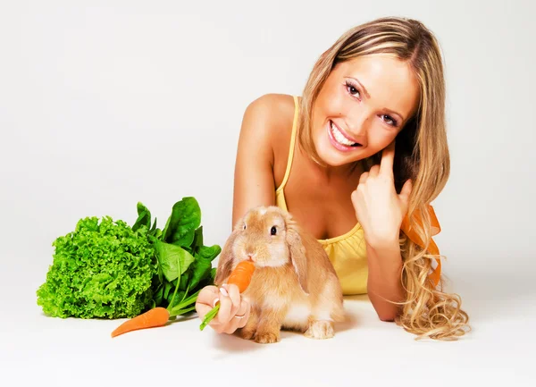 Ziemlich fröhliches Mädchen, das ein Kaninchen füttert — Stockfoto