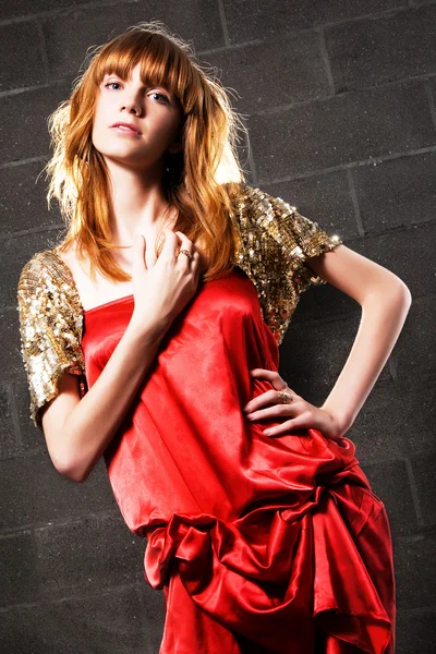 サテンの赤いドレスを着たファッショナブルな赤髪の女 — ストック写真