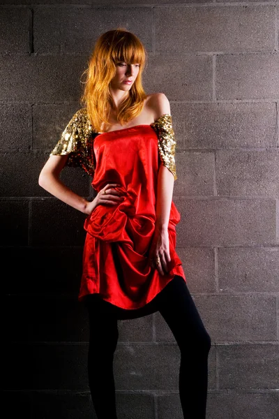 Donna dai capelli rossi alla moda in un abito rosso satinato — Foto Stock