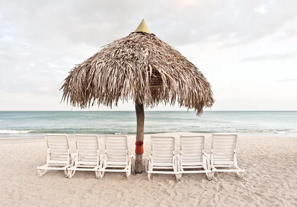 Plage de sable, parasol et chaises longues — Photo