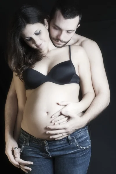 Szczęśliwy w ciąży i ojca na czarnym tle pieszczot dzwon — Zdjęcie stockowe